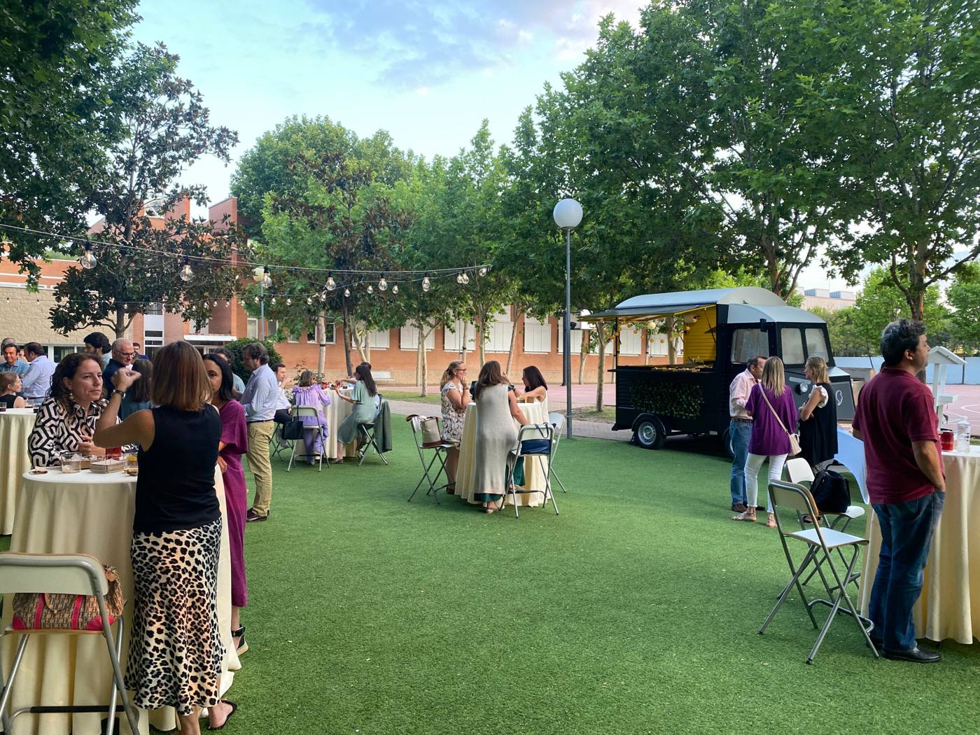 Invitados en un evento privado al aire libre con el food truck al fondo