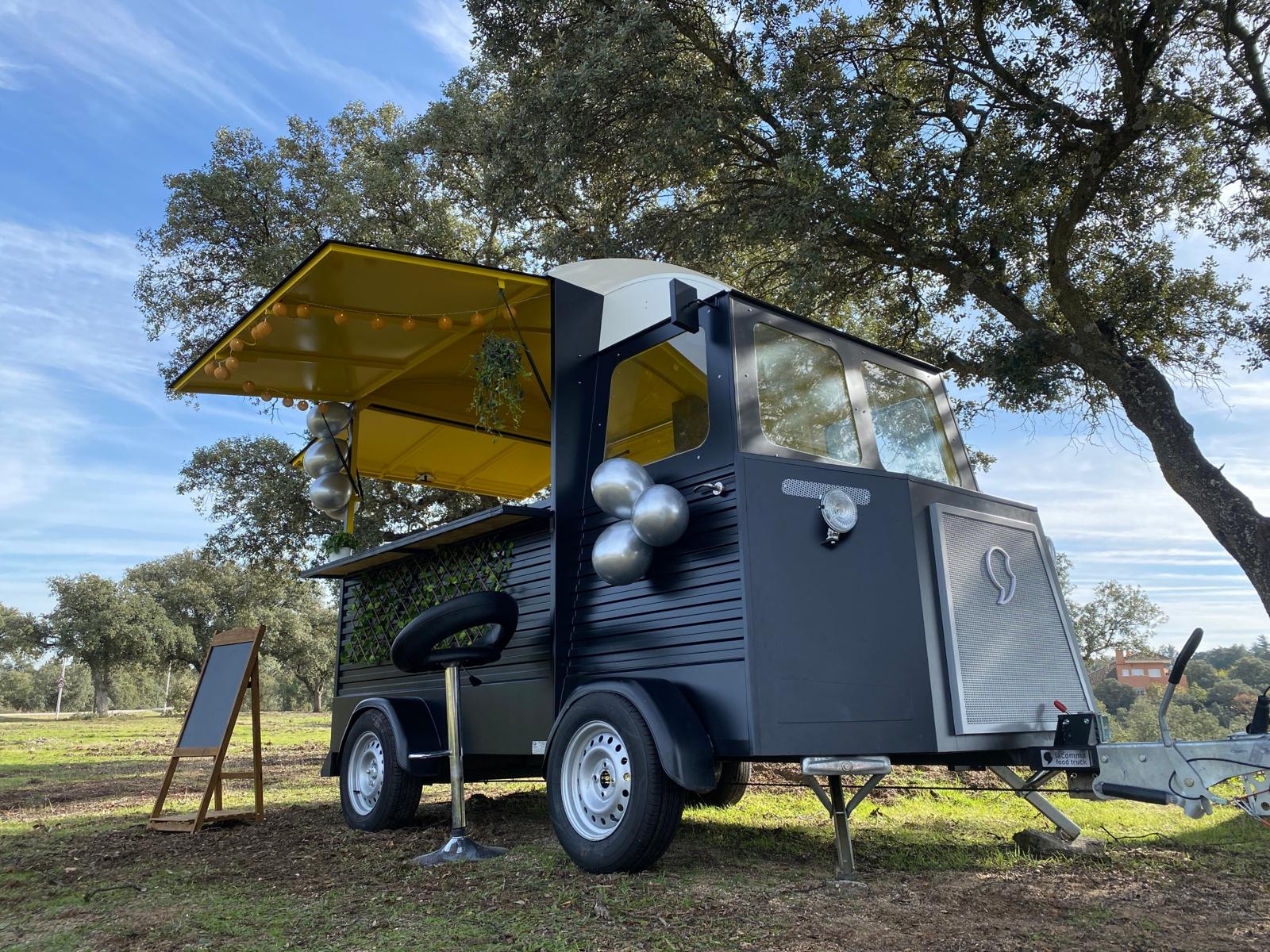 Vista frontal del food truck con el toldo amarillo abierto